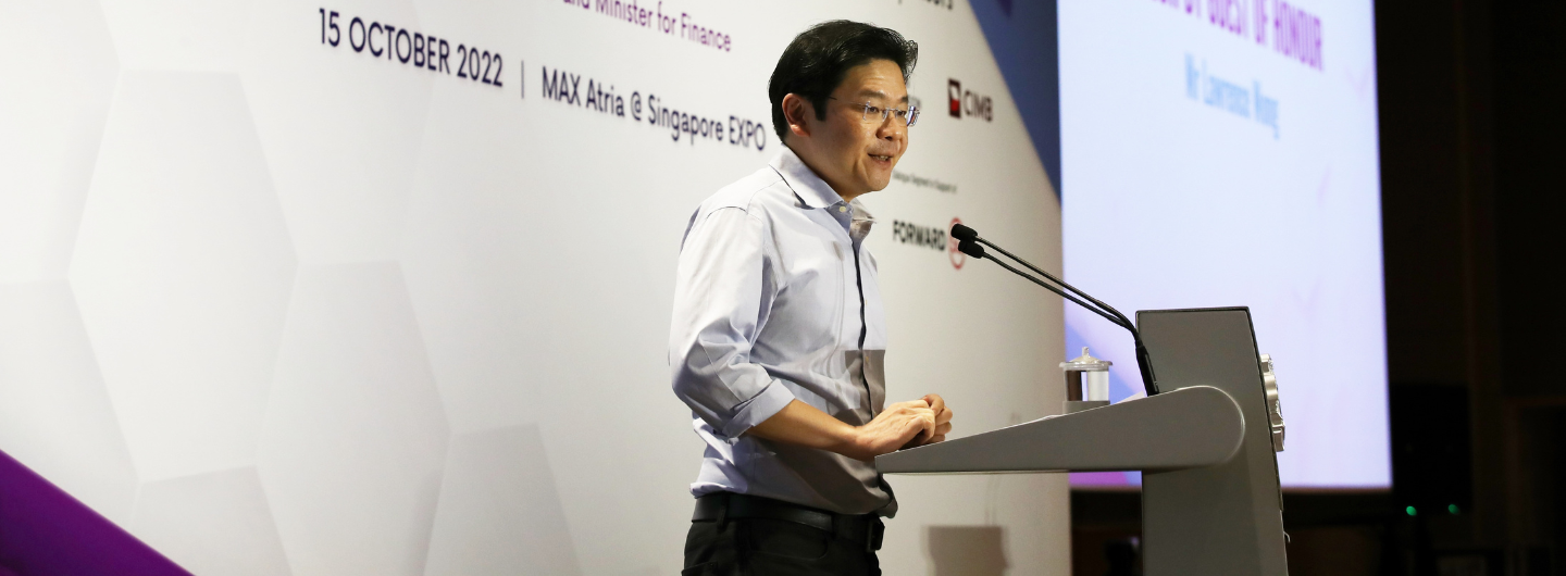 Lawrence Wong at a podium with microphones during a presentation.